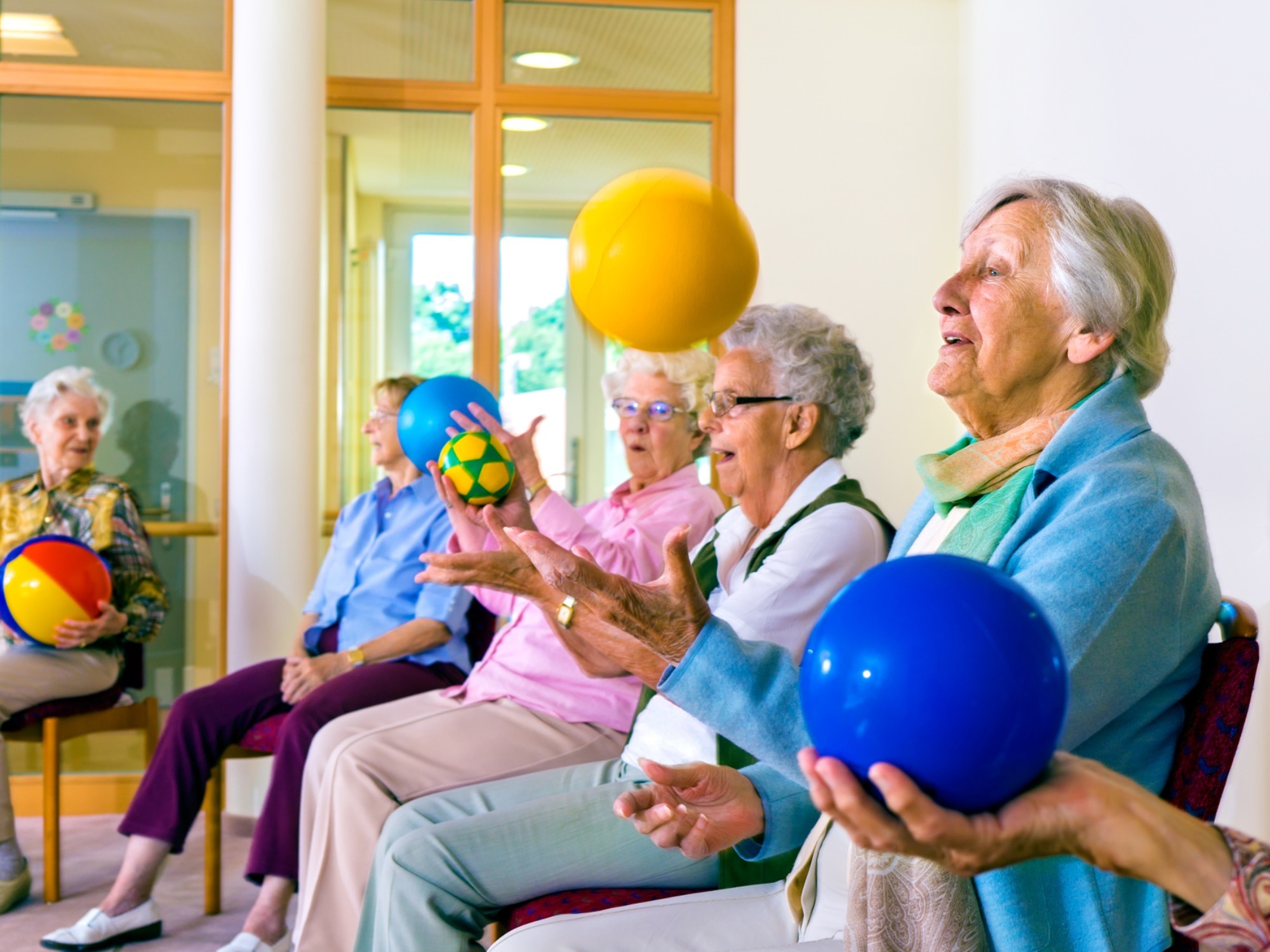 Older people doing an activity with balloons.