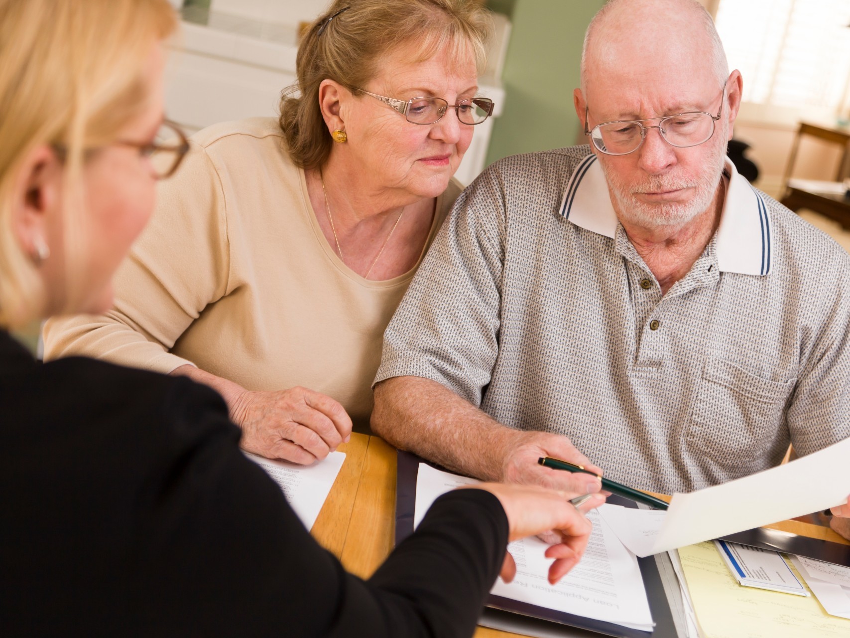Older couple sorting out their finances with a financial planner