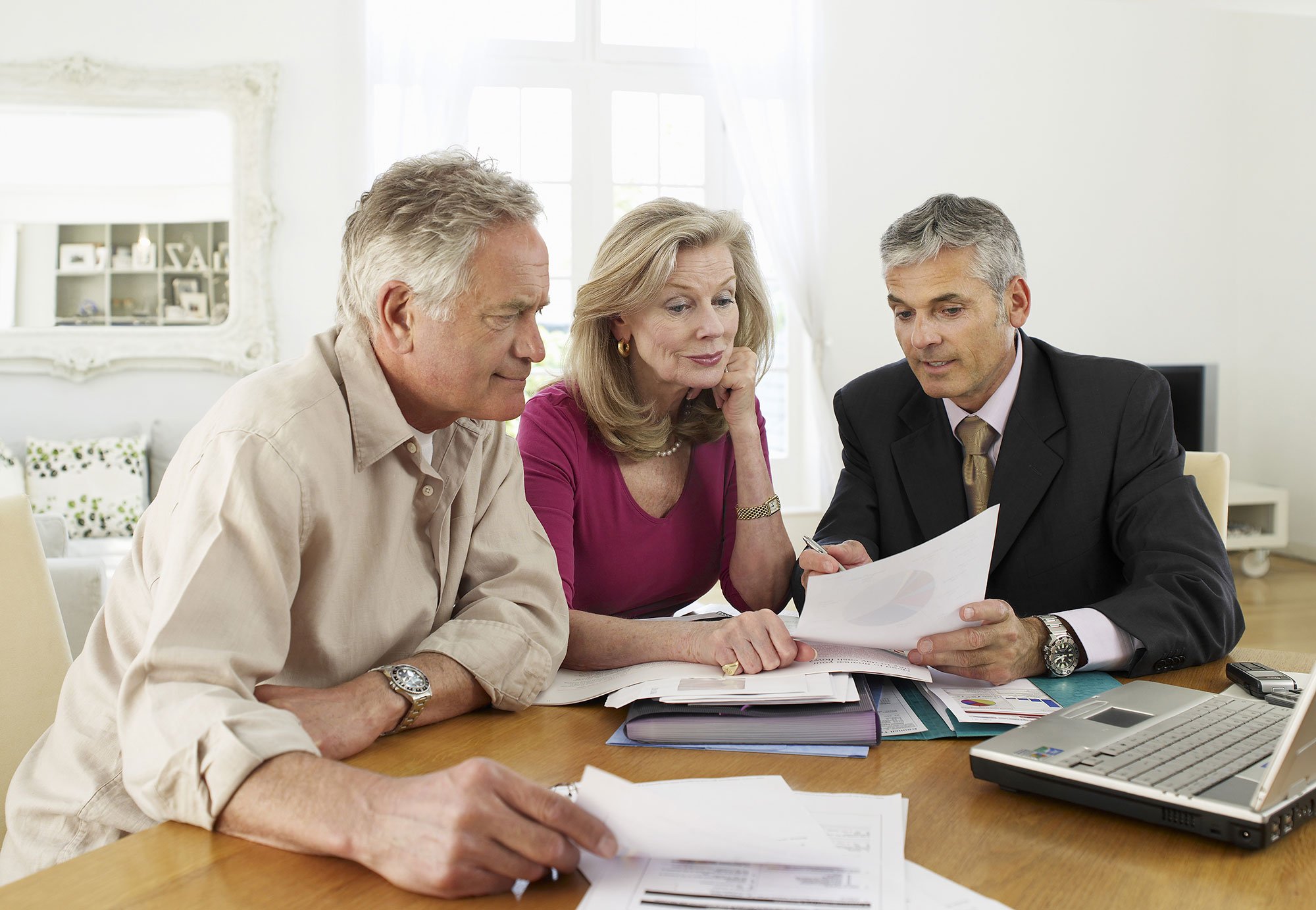 A financial advisor giving information to senior couple