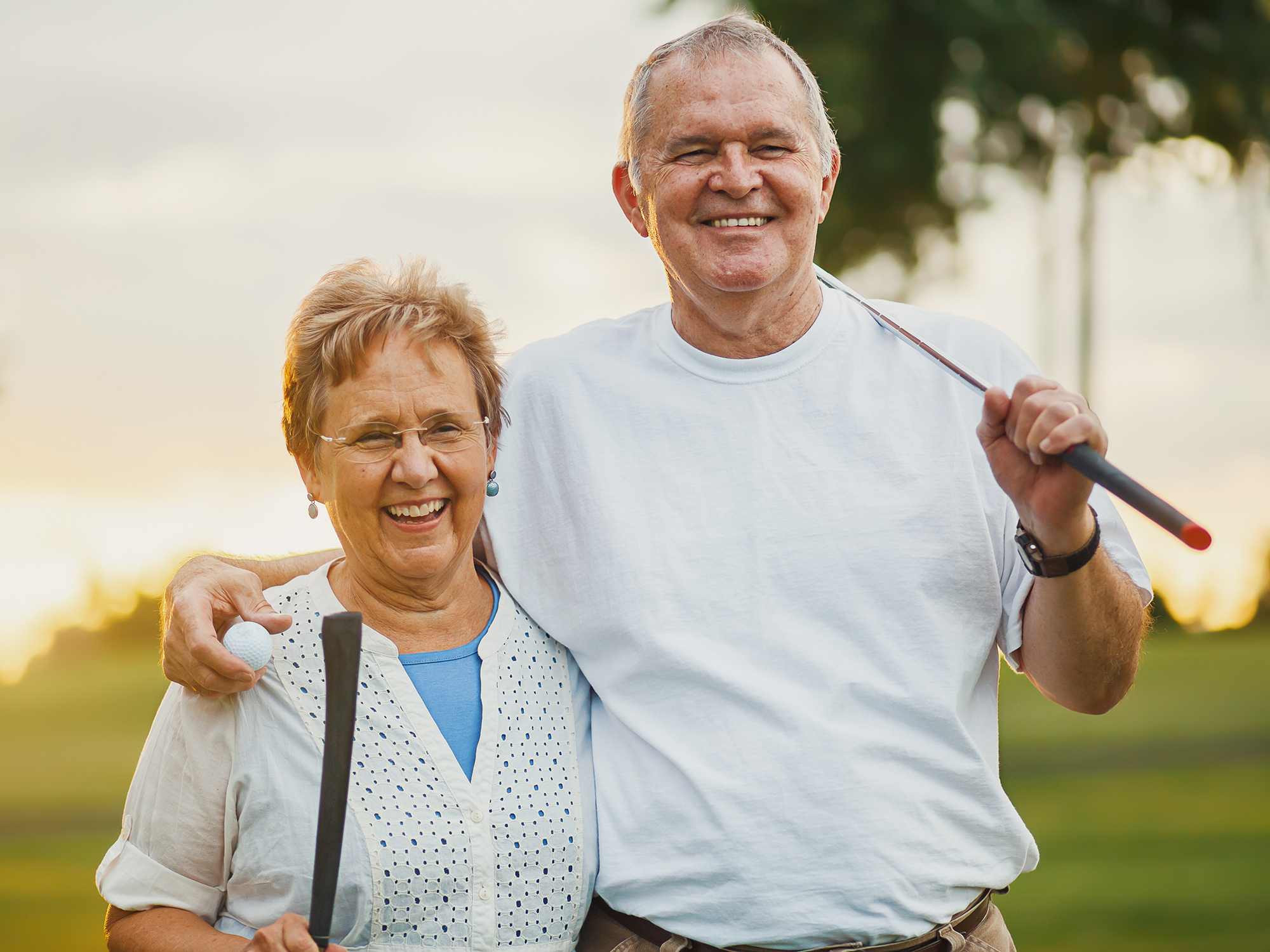 Happy retired couple playing golf