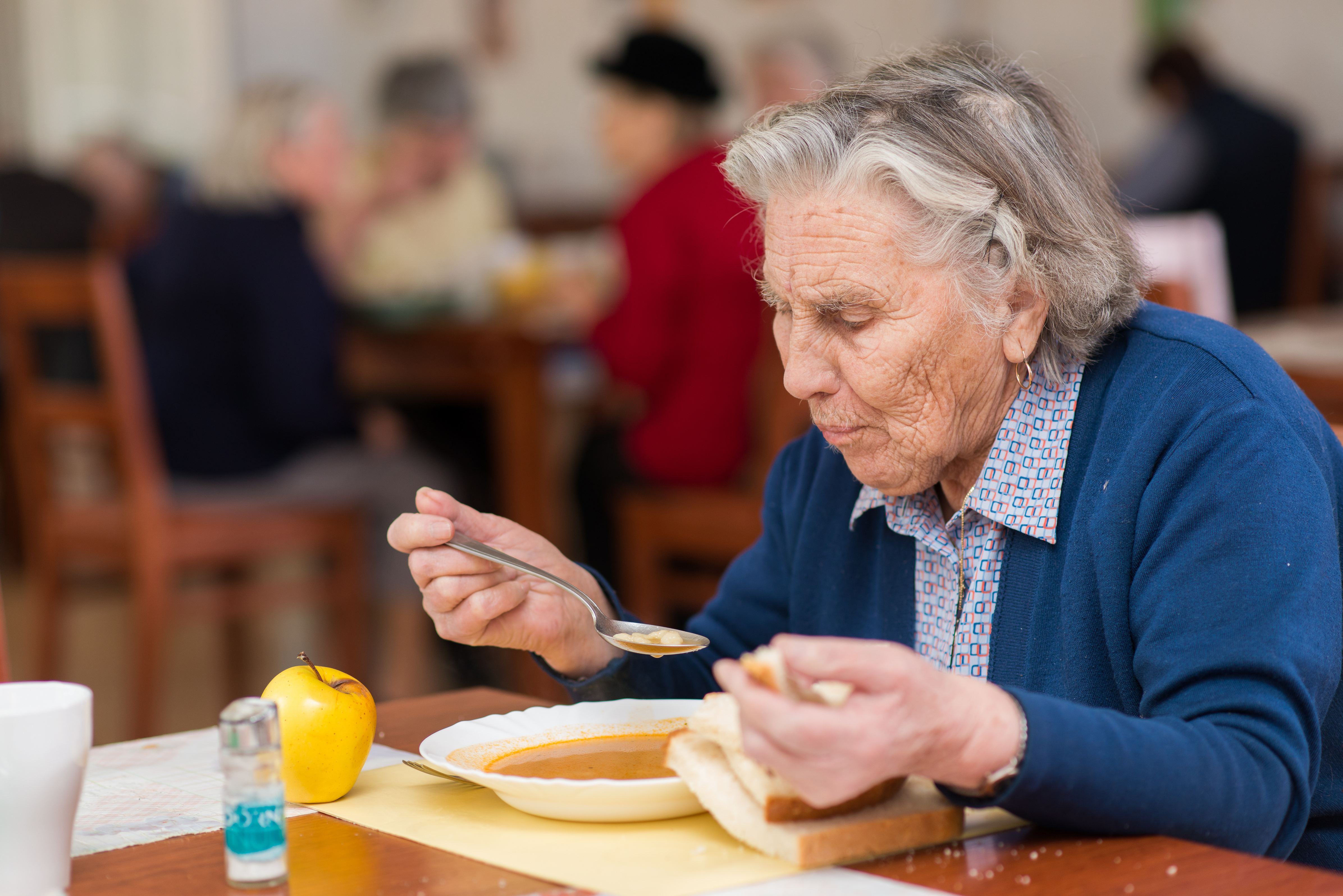Older woman in aged care having soup.