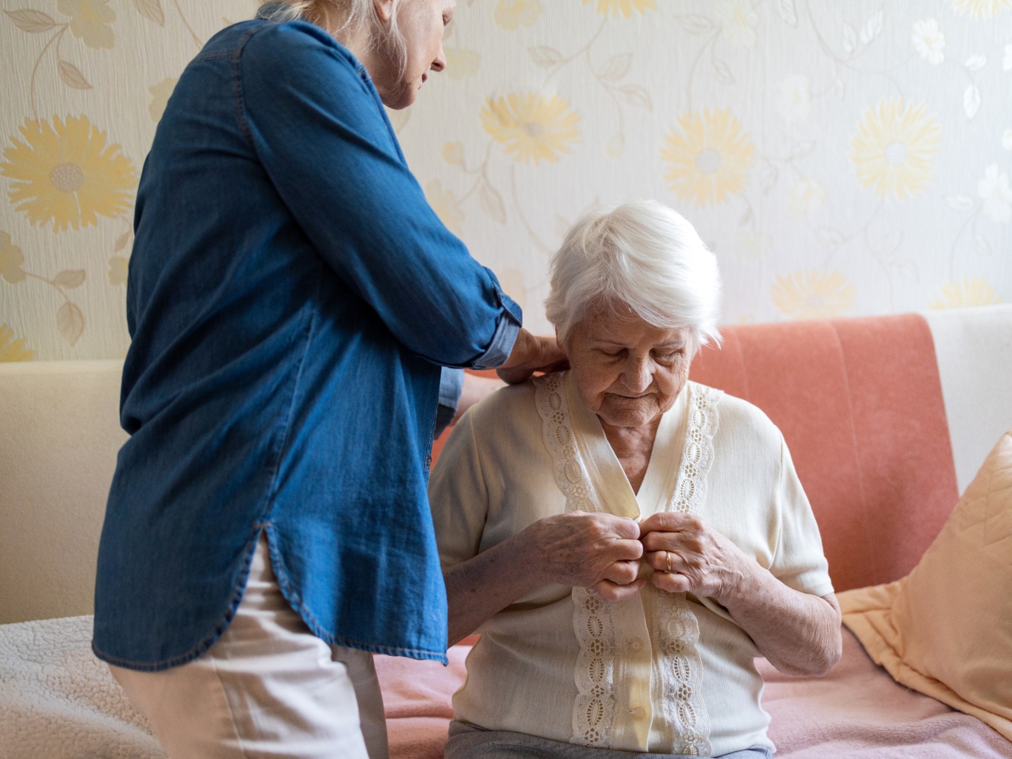 Older woman receives help at home from a carer