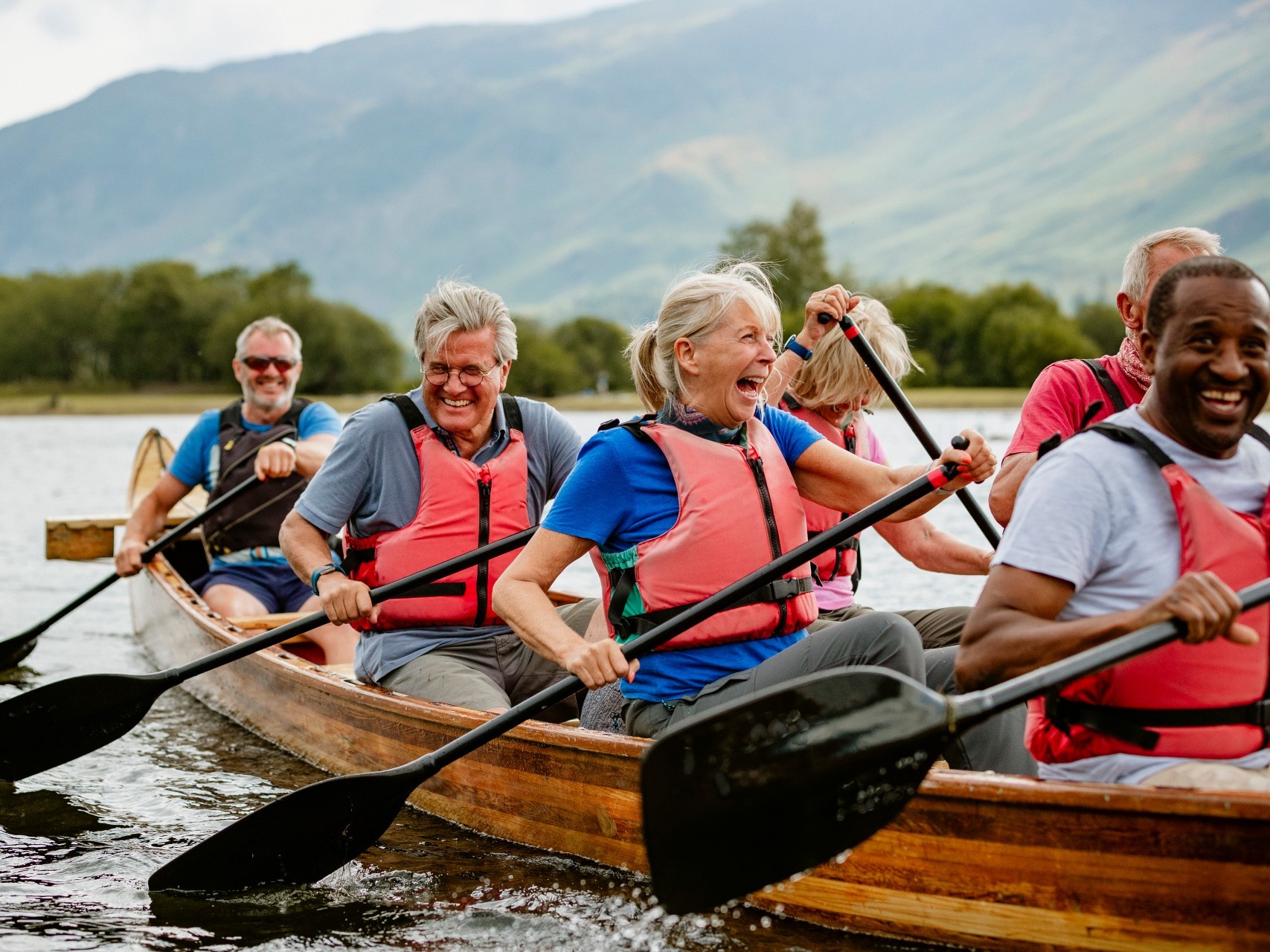 Older group of people paddling a boat